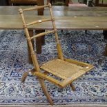 An early 20th century golden oak folding chair, with wicker seat