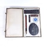 A cased Japanese set comprising brushes, ink, porcelain pot, mixing palette etc, box length 25.5cm