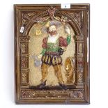 A large 19th century polychrome glazed plaster relief wall plaque, depicting a man in Tudor clothing