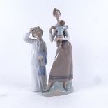 A large Lladro porcelain group, lady holding a child, and a NAO figure of a boy in a nightgown,