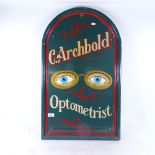 A painted wood sign advertising C Archbold Optometrist