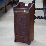 A late Victorian oak smoker's cabinet of small size, with carved panelled door and drawer under,