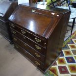 A George III oak bureau, with shaped fitted interior, 3 short and 3 longs drawers under, W94cm,