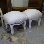 A pair of white painted and upholstered footstools