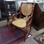 An ornate bentwood armchair, with scroll arms and cane seat and back, in the manner of Thonet