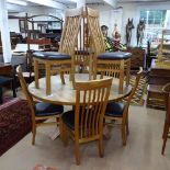 A large circular solid oak dining table on abstract base, W150cm, H76cm, together with a set of 8