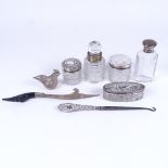 A collection of silver-topped scent and perfume bottles, a silver-handled button hook etc