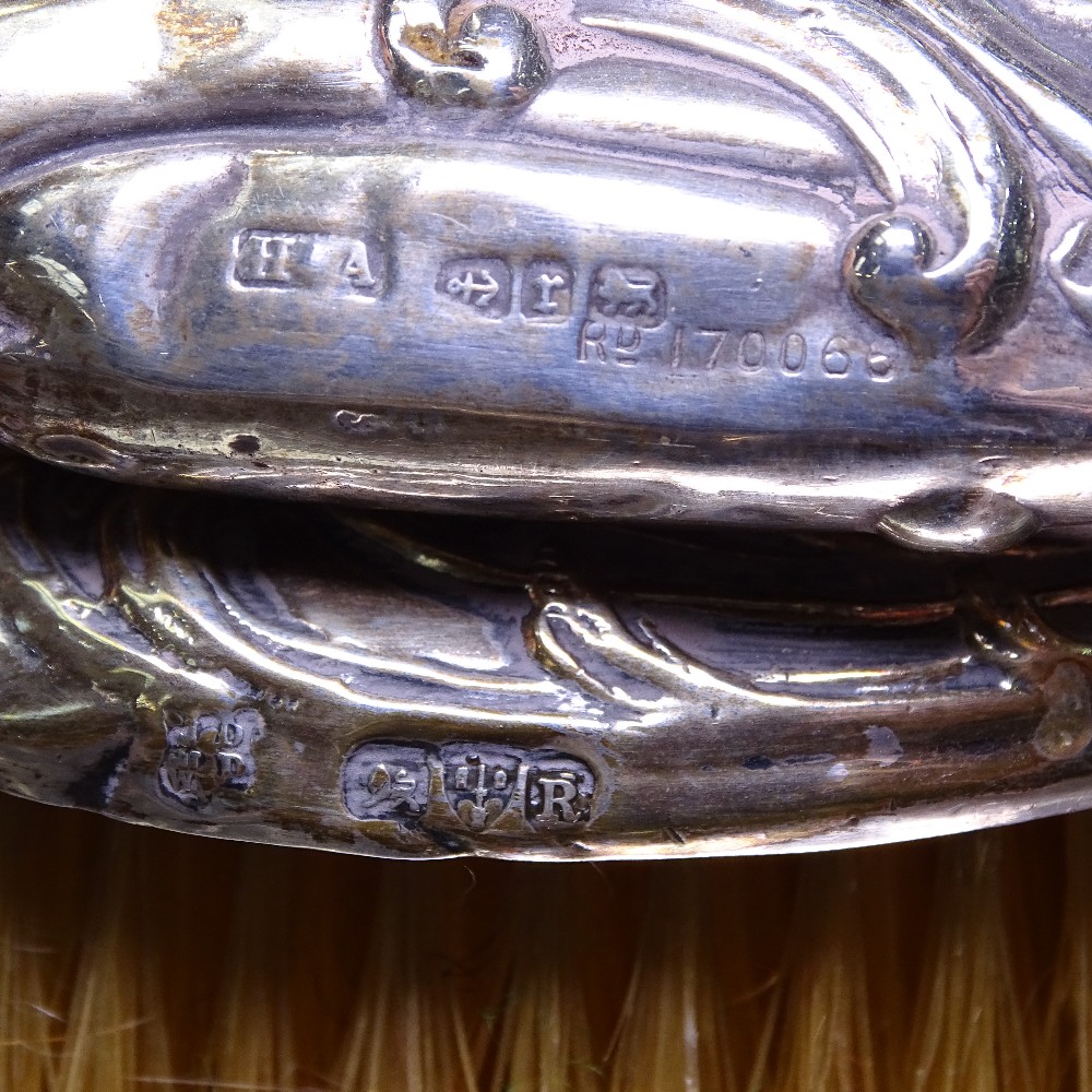 An Art Nouveau silver-backed embossed dressing table brush, a silver-backed table mirror, and a - Image 2 of 2
