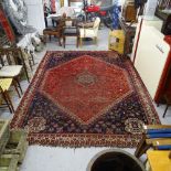 A large red ground Shiraz carpet, 310cm, x 225cm