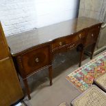 A Regency style mahogany serpentine-front sideboard, fitted drawers and cupboards, on square tapered