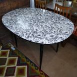 A mid-century formica dining table, with black and white floral design top and ebonised legs,