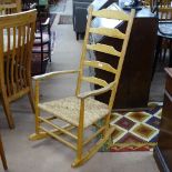 An Arts and Crafts Cotswold School style ladder-back rocking chair in ash, with rush seat,