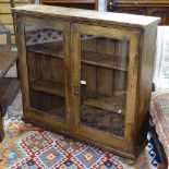 An Antique pine 2-door bookcase on bun feet, W102cm, H98cm, D25cm