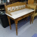 An Edwardian pine washstand, with a raised tile back and marble top, W107cm