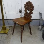 An Italian style oak hall chair with figural carved back