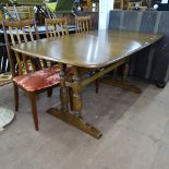 A modern Ercol dark elm extending dining table, with integral spare leaf, on turned leg base,