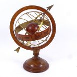 A table-top brass-mounted armillary sphere, with zodiac and turned wood base, height 35cm