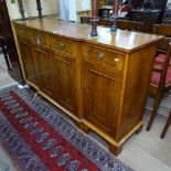 A reproduction cross-banded yew wood break-front sideboard, fitted with drawers and cupboards, on