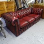 A red leather button-back upholstered 2-seater Chesterfield settee
