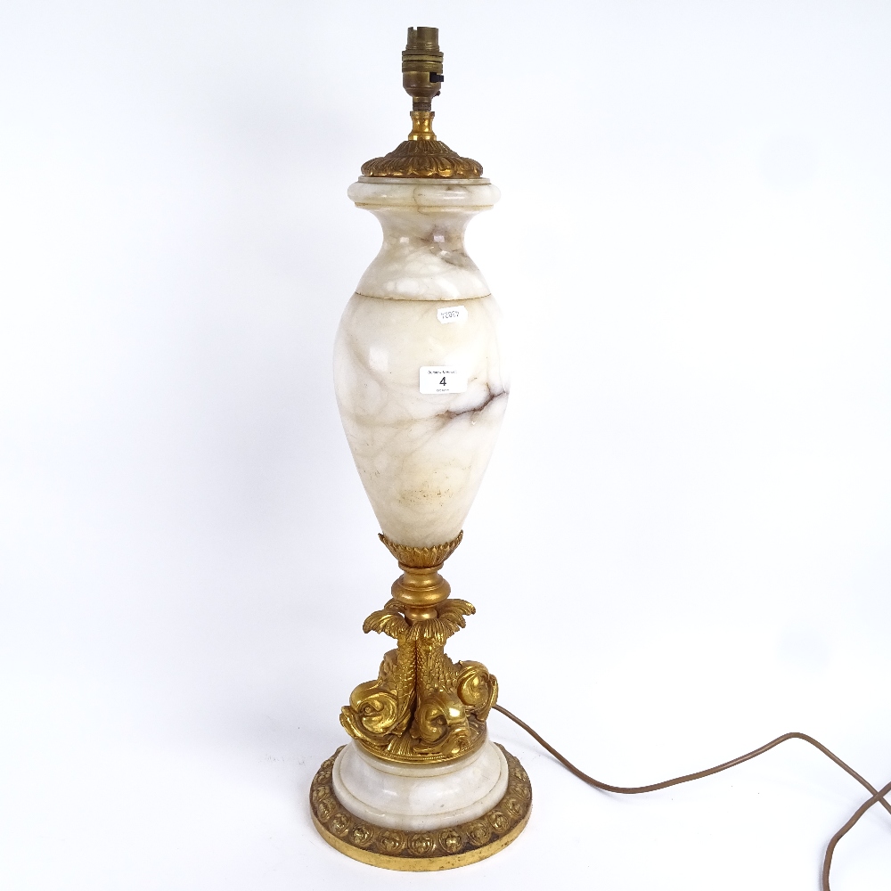 A large white marble and gilt-bronze mounted urn table lamp, with quadruple dolphin support,