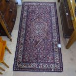 A red ground wool Persian design rug, 180cm x 90cm