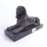 A modern Egyptian Revival bronzed spelter Sphinx sculpture, on black slate base, length 28cm