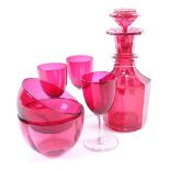 A cranberry glass decanter, two cranberry glass finger bowls and three glasses, decanter height