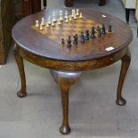 A 1930s circular oak games-top table on cabriole legs, complete with chess set, W60cm, H44cm