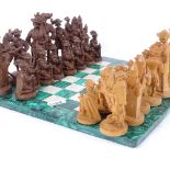 A chess set of composite Medieval figures, King height 9cm, on a malachite and hardstone board