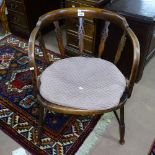 A stained beech bow-back desk chair with cane seat