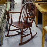 A stained beech wheel-back rocking chair