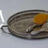 An Art Nouveau silver-backed embossed dressing table brush, a silver-backed table mirror, and a