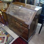 A Georgian mahogany bureau, having a well and drawer fitted interior, graduated drawers under, on