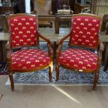 A pair of Empire style mahogany open armchairs, with musical motif red upholstery