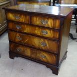 A reproduction cross-banded mahogany chest of 2 short and 3 long drawers, with bracket feet,