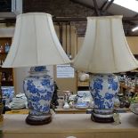 A pair of blue and white ceramic jars and covers converted to table lamps, with shades, overall