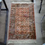 A pair of silk and wool Persian design rugs, 100cm x 65cm, and a Belgian silk and wool rug, 108cm