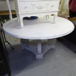 A large circular white painted dining table, on scrolled platform base, W148cm, H74cm