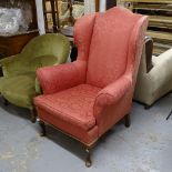 An Edwardian upholstered wing armchair