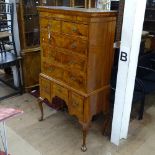 A Queen Anne style walnut chest on stand, the top having 2 short and 3 long cross-banded drawers