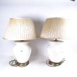 A pair of ceramic table lamps with cream shades, height 54cm