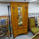 An Art Nouveau walnut single mirror-door wardrobe