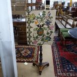 A 19th century mahogany and satinwood-strung pole screen with needlework banner