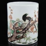 A Chinese white glaze porcelain brush pot, with painted bird and blossom tree, height 12cm, diameter