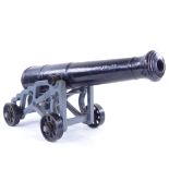 A cast-iron starting cannon, on original grey painted cast-iron wheeled carriage base, barrel length