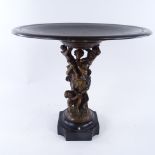 A patinated bronze table centre tazza supported by a woman and cherubs, on slate base, height
