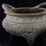 A Chinese bronze 2-handled incense burner, with dragon decorated frieze raised on 3 feet,