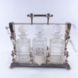 A Victorian electroplate 3 bottle tantalus, containing square cut glass decanters with stoppers,