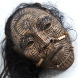 An unusual composition Tribal head wall mask, with painted face and real hair, life-size, probably