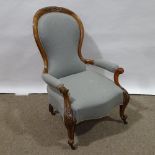 A Victorian walnut-framed open-arm fireside chair Reupholstered but there is some minor staining and